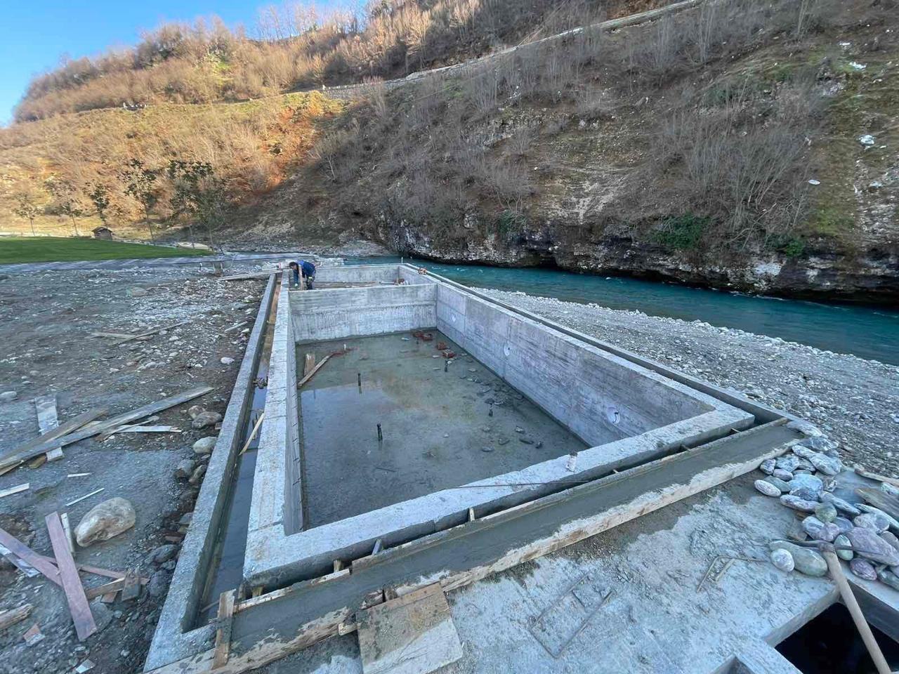 Themeli i betonit i hapur pranë lumit, para betonimit