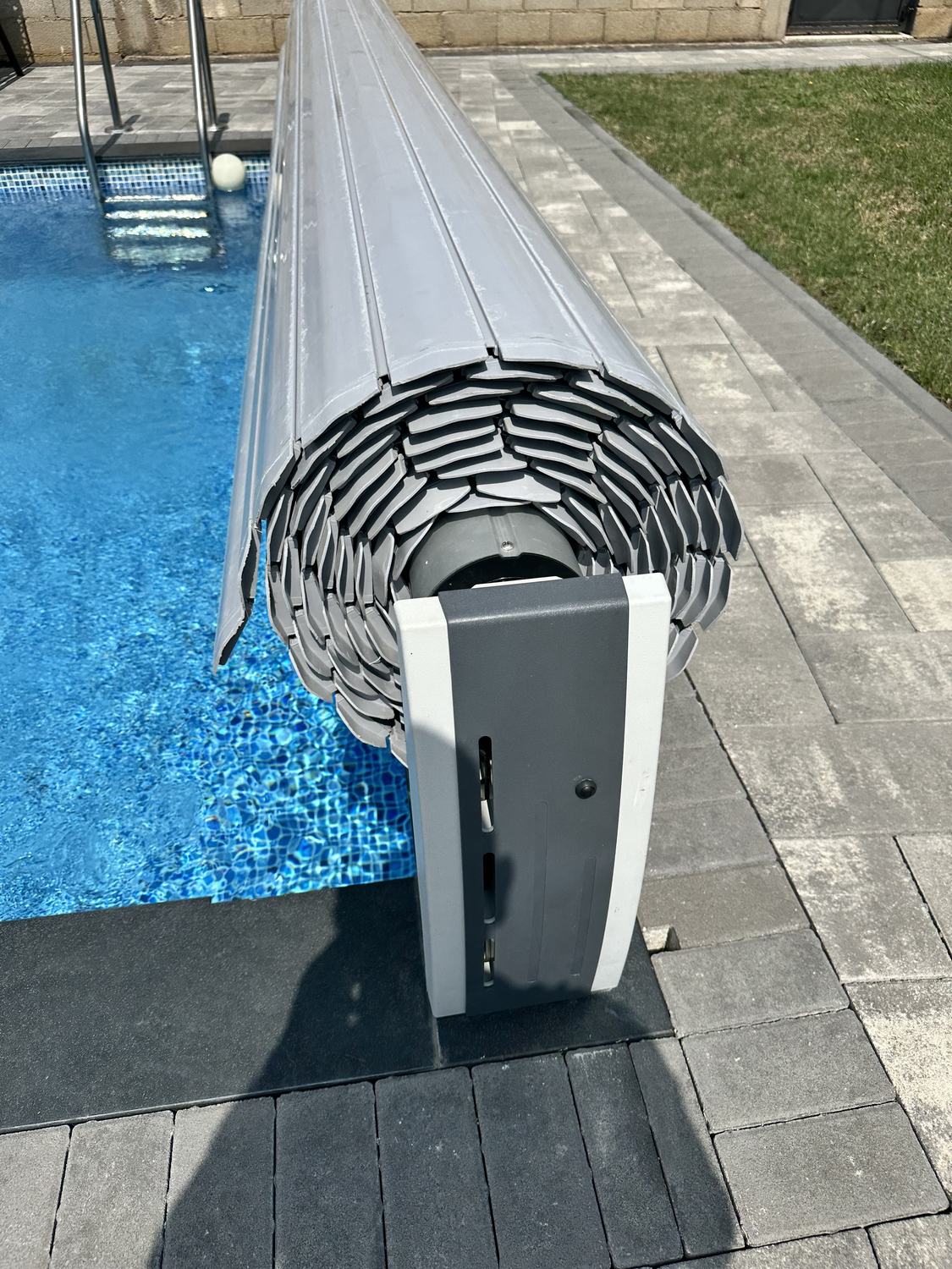 Boshti i mbulesës automatike në buzë të pishinës