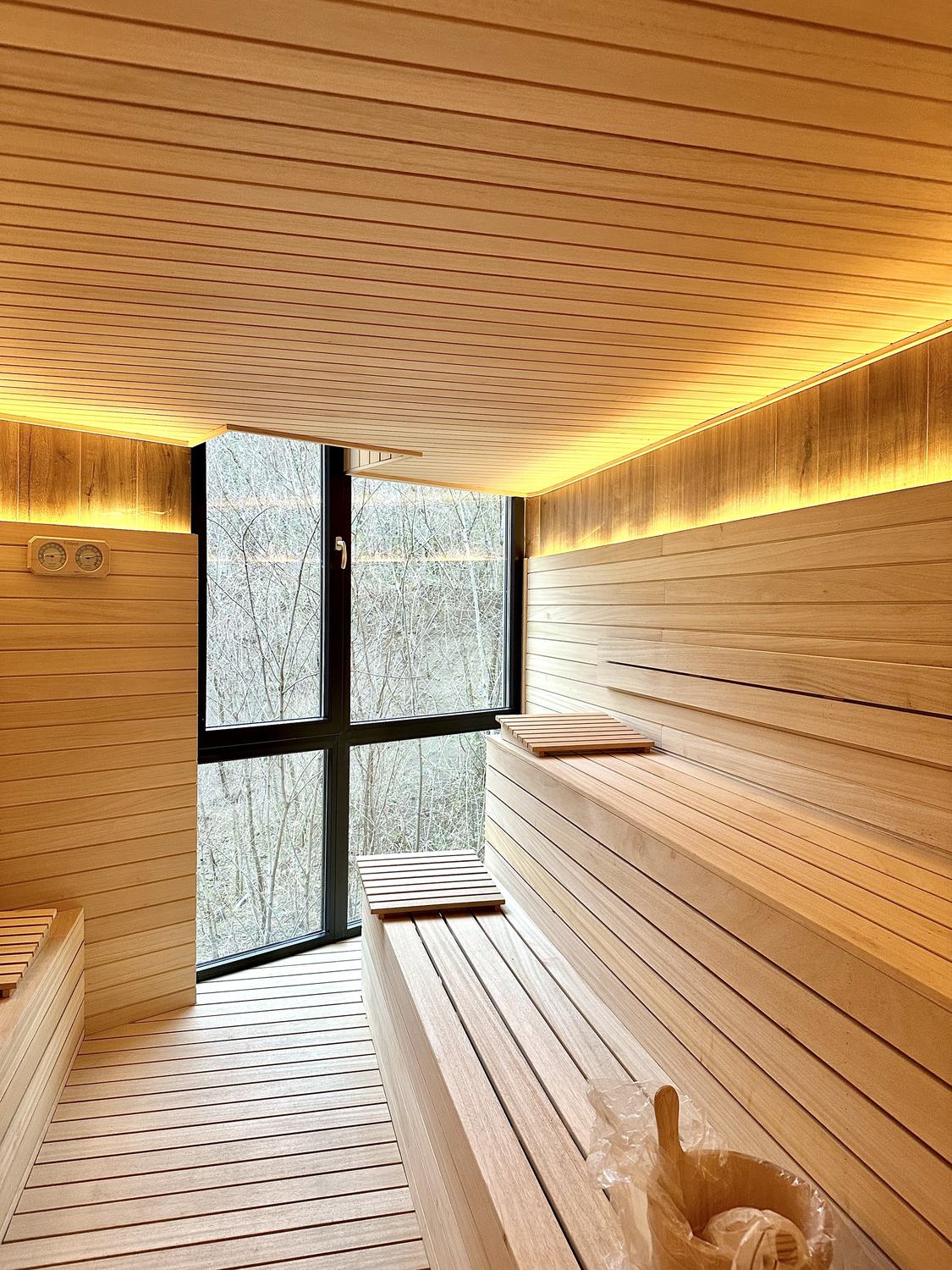 Sauna me pamje nga dritarja dhe stola druri