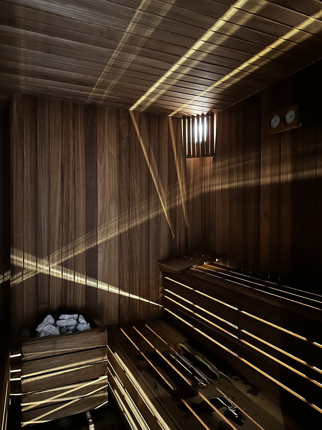 Sauna me dru të errët dhe dritë të fshehur pas dërrasave